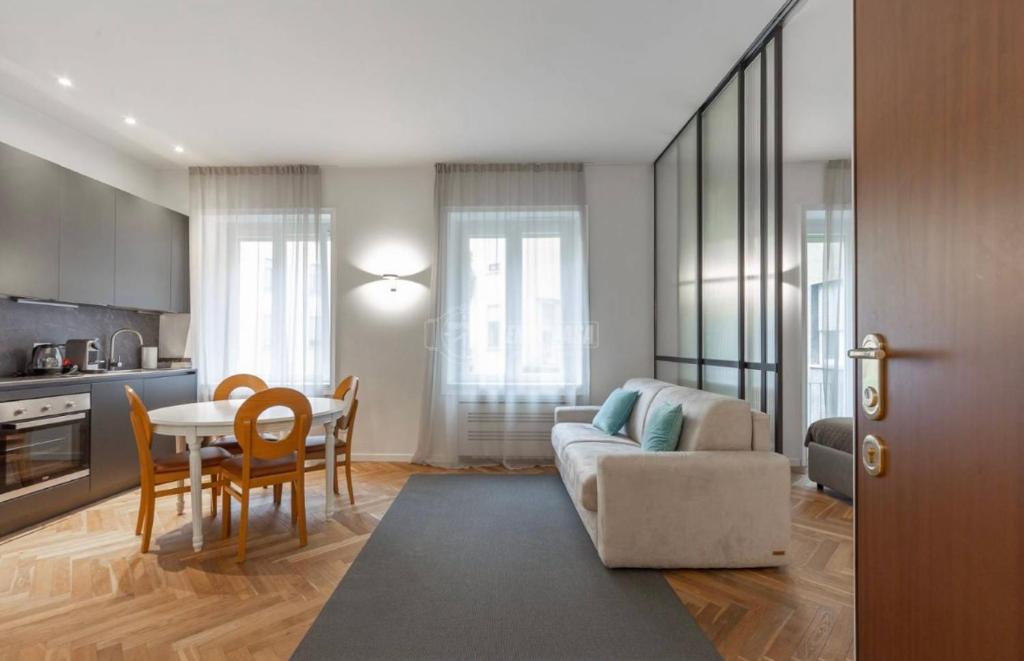 een woonkamer met een bank en een tafel bij Milano - delizioso appartamento in pieno centro. Fancy yellow apartments in Milaan