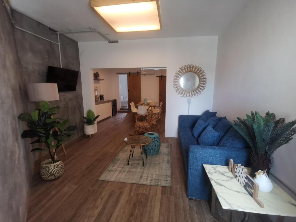 ein Wohnzimmer mit einem blauen Sofa und einem Tisch in der Unterkunft Torre Mar Frente al Malecón Departamento 3 in Mazatlán