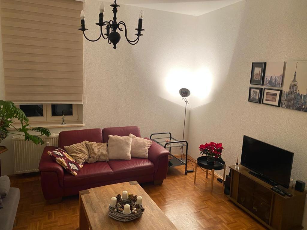 sala de estar con sofá rojo y mesa en Schöne Altbauwohnung mit Grün in ruhiger Lage, en Leipzig