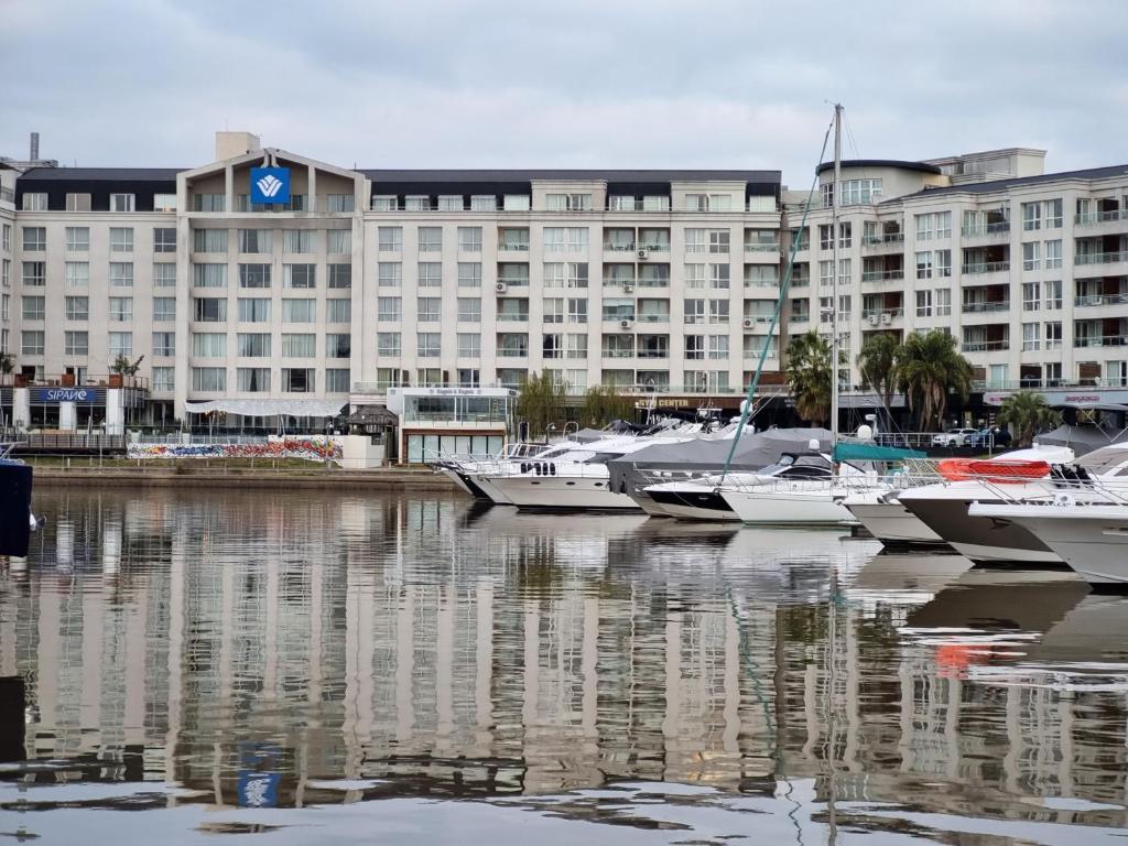 un grand bâtiment avec des bateaux amarrés dans un port dans l'établissement Departamentos Condominio Wyndham Nordelta - Desayuno y Spa Opcional !, à Tigre