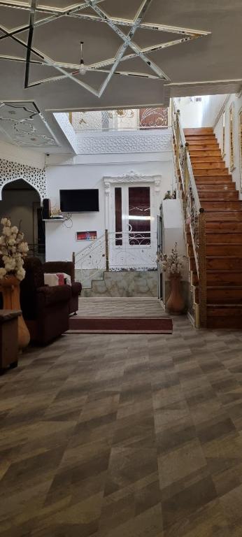 a large living room with a couch and a staircase at Hotel Guest House GOLDEN DEGREZ in Bukhara
