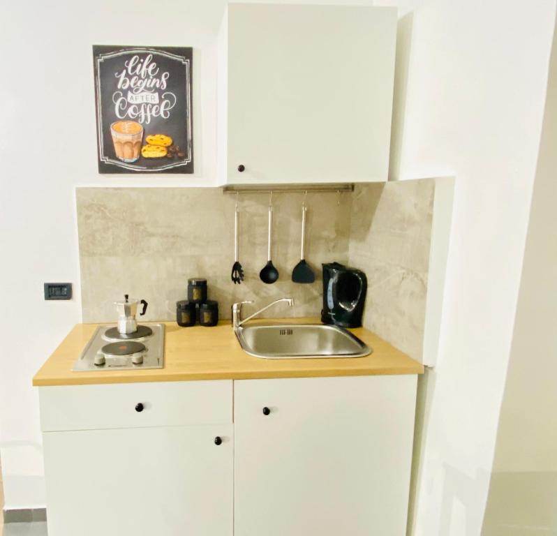 een keuken met witte kasten en een wastafel bij Figurari Home Napoli-2 in Napels