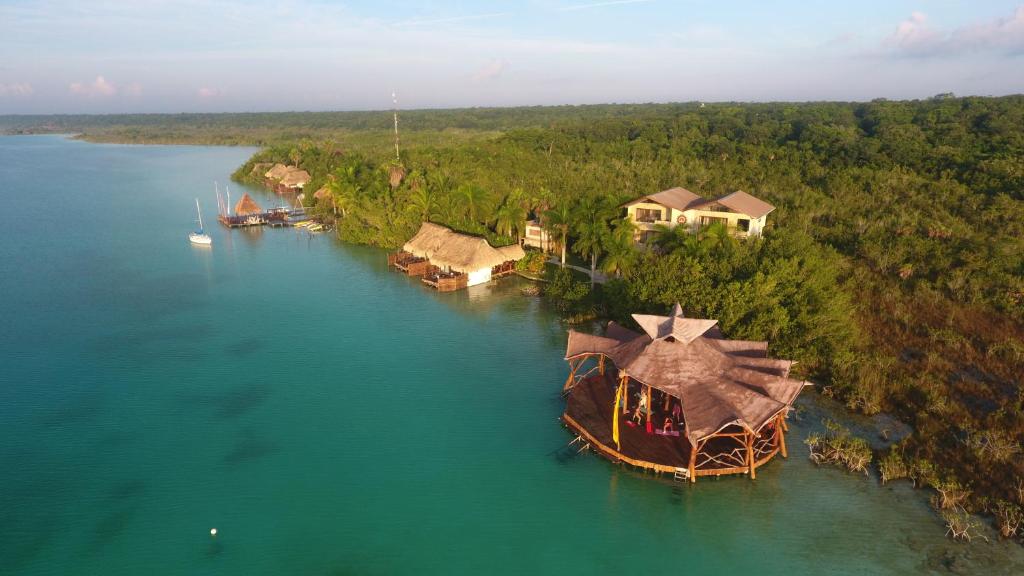 an island with a large boat in the water at Akalki Hotel y Centro Holistico in Bacalar