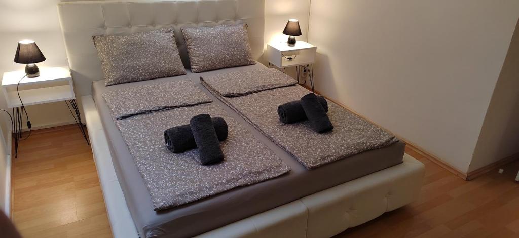 ein Schlafzimmer mit einem Bett mit zwei Kissen darauf in der Unterkunft Paris Night in Niš