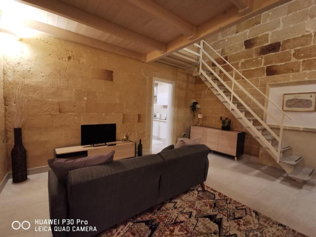 a living room with a couch and a brick wall at Appartamento Pittori in Manduria