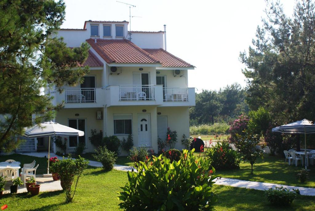 a white house with a balcony and a yard at Villa Iris in Prinos