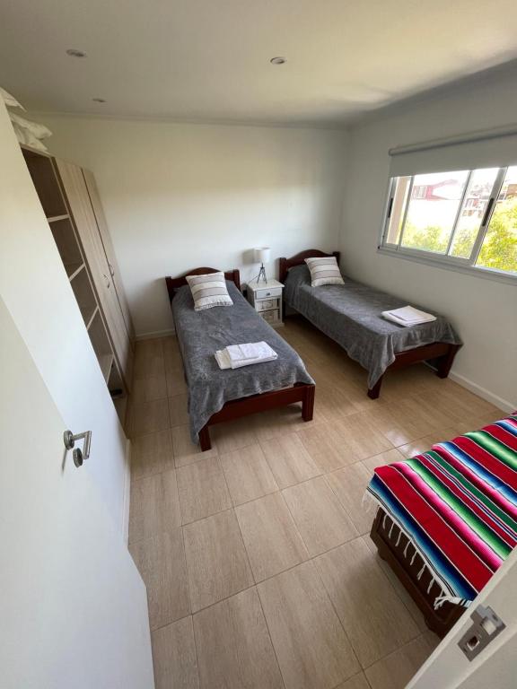 ein Wohnzimmer mit 2 Betten und einem Fenster in der Unterkunft Casa Tamarisco in Camet Norte