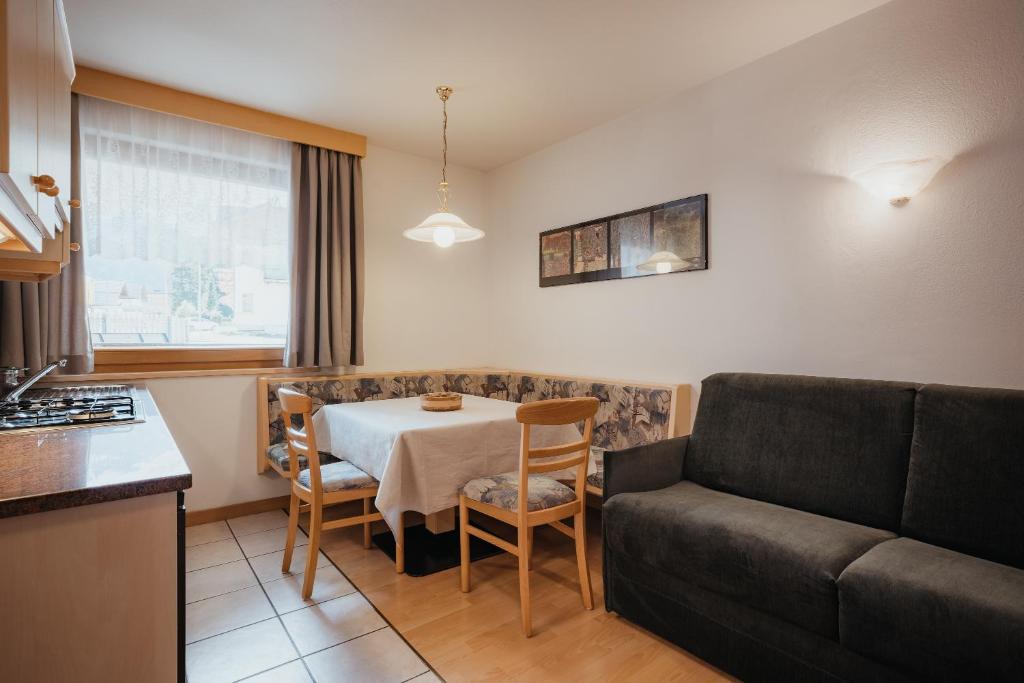 sala de estar con mesa y sofá en Residence Chalet Pinis, en Corvara in Badia
