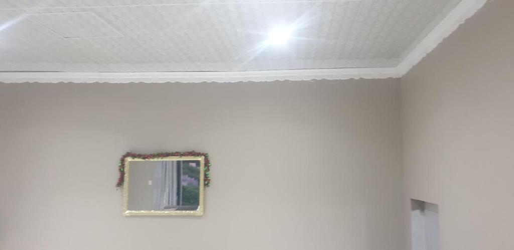 un espejo en una pared blanca con techo en Kailas Guest en Queensburgh