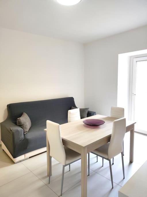 a dining room with a table and a couch at Central rooms in Agira