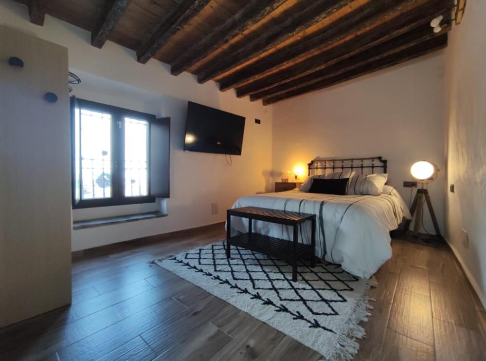 a bedroom with a bed and a television on the wall at Casa Fina in Albanchez de Magina