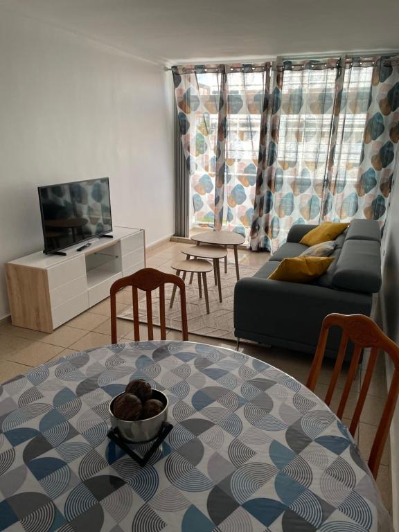 uma sala de estar com uma mesa e um sofá em Appartement Cosy Pointe-à-Pitre em Pointe-à-Pitre