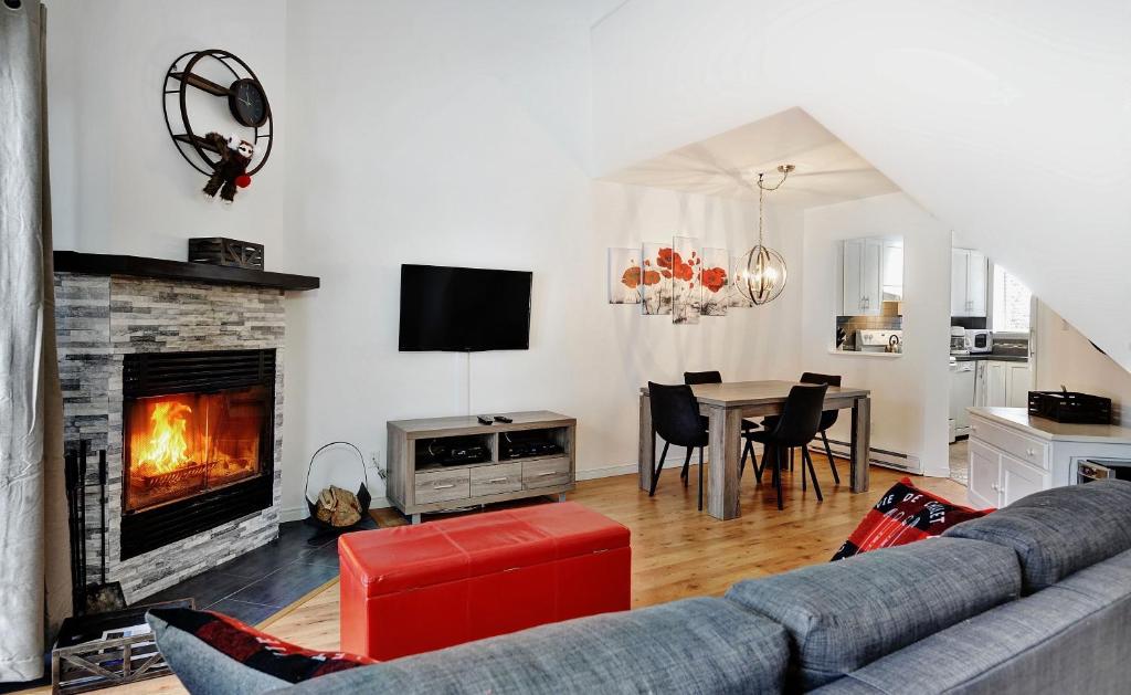 a living room with a couch and a fireplace at 31#33 Chemin du Hameau in Stoneham