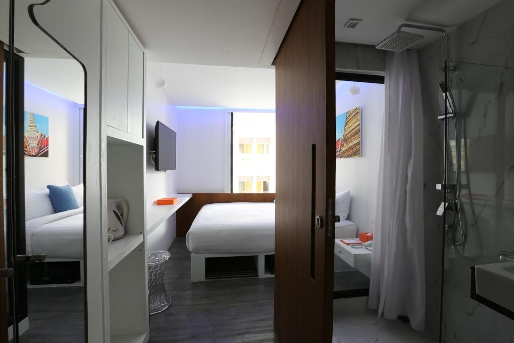 a hotel room with a bed and a bathroom at S Box Sukhumvit Hotel - SHA Extra Plus in Bangkok