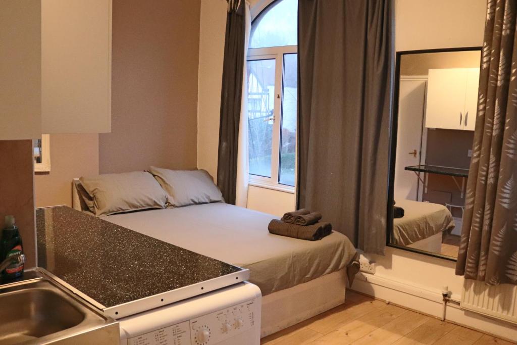 a small room with a bed and a mirror at Studio on Finchley Road in London