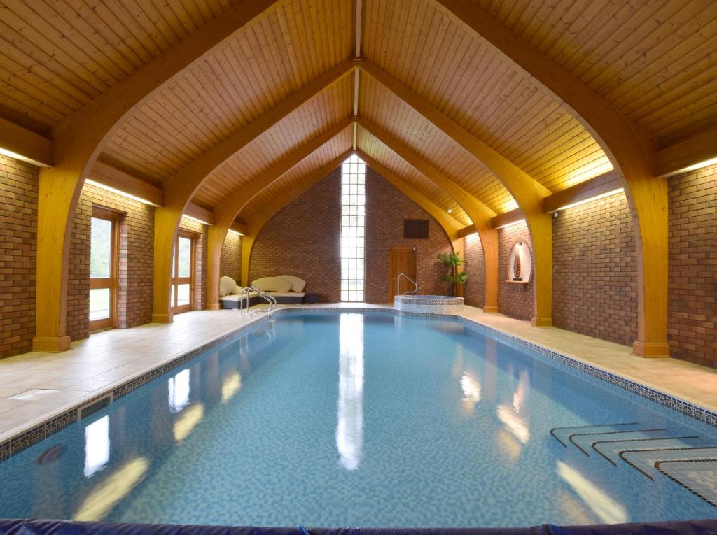 uma grande piscina interior com tecto de madeira em Solway em Chester