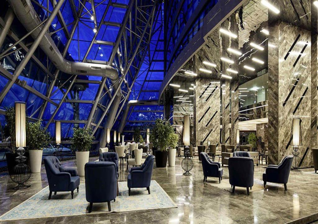 eine Lobby mit Stühlen und Tischen in einem Gebäude in der Unterkunft Prime Istanbul in Istanbul