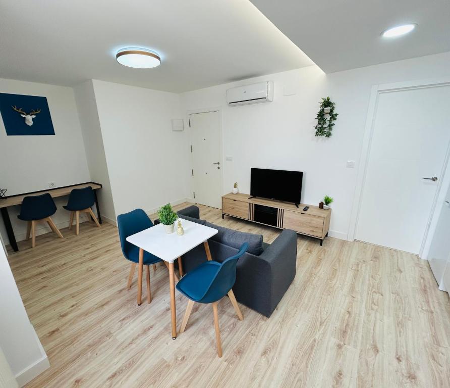 a living room with a table and a couch and a tv at VIP -Apartamentos Birdie- in Albacete