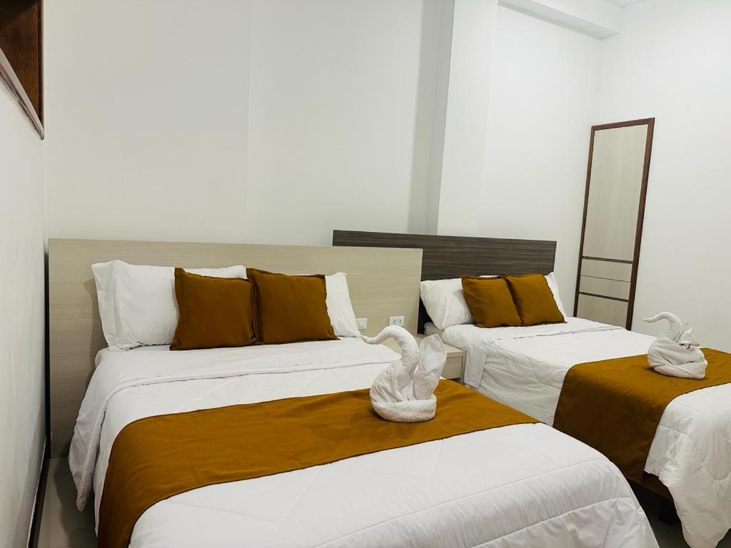 a bedroom with two beds with towels on them at Hotel Overland in Paracas