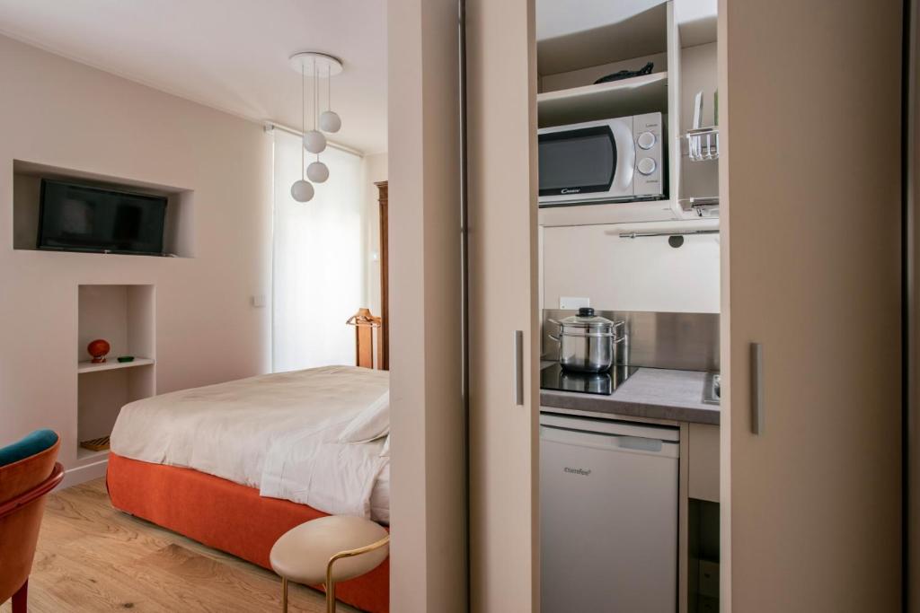 um pequeno quarto com uma cama e uma cozinha em una stanza in carmine em Brescia