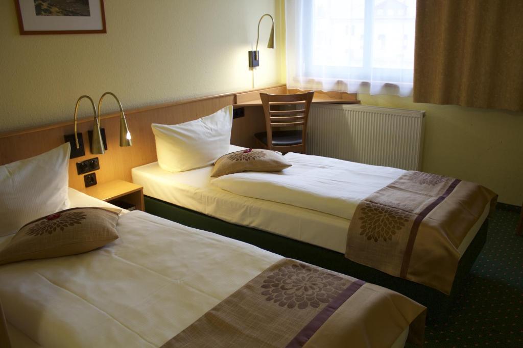 Postel nebo postele na pokoji v ubytování ACRON Hotel Wittenberg