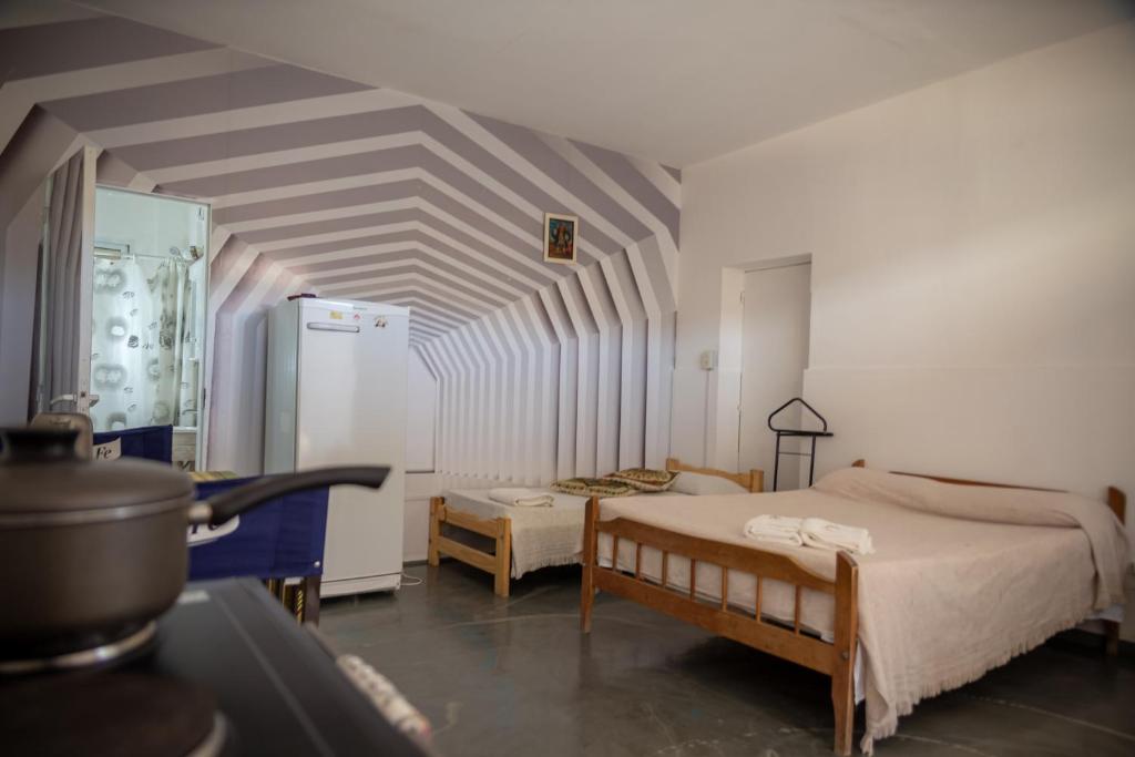 Habitación con 2 camas y nevera. en Apart La Cantora en Gualeguaychú