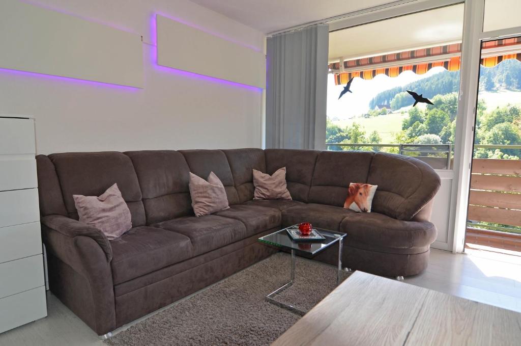 a brown couch in a living room with a table at BFE Schwarzwaldnest in Baiersbronn