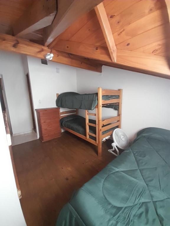 1 dormitorio con cama verde y techo de madera en Departamento tipo duplex en San bernardo n°3 en San Bernardo
