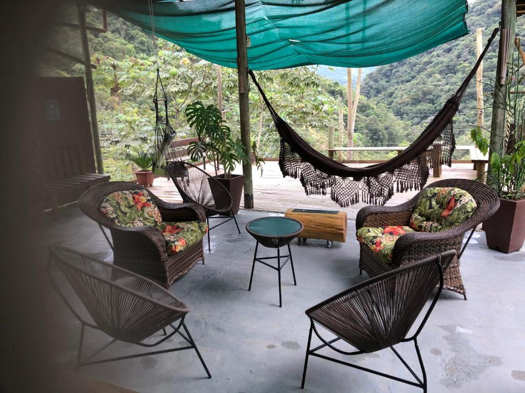 een patio met stoelen, een tafel en een hangmat bij Pousada São Francisco PETAR in Iporanga