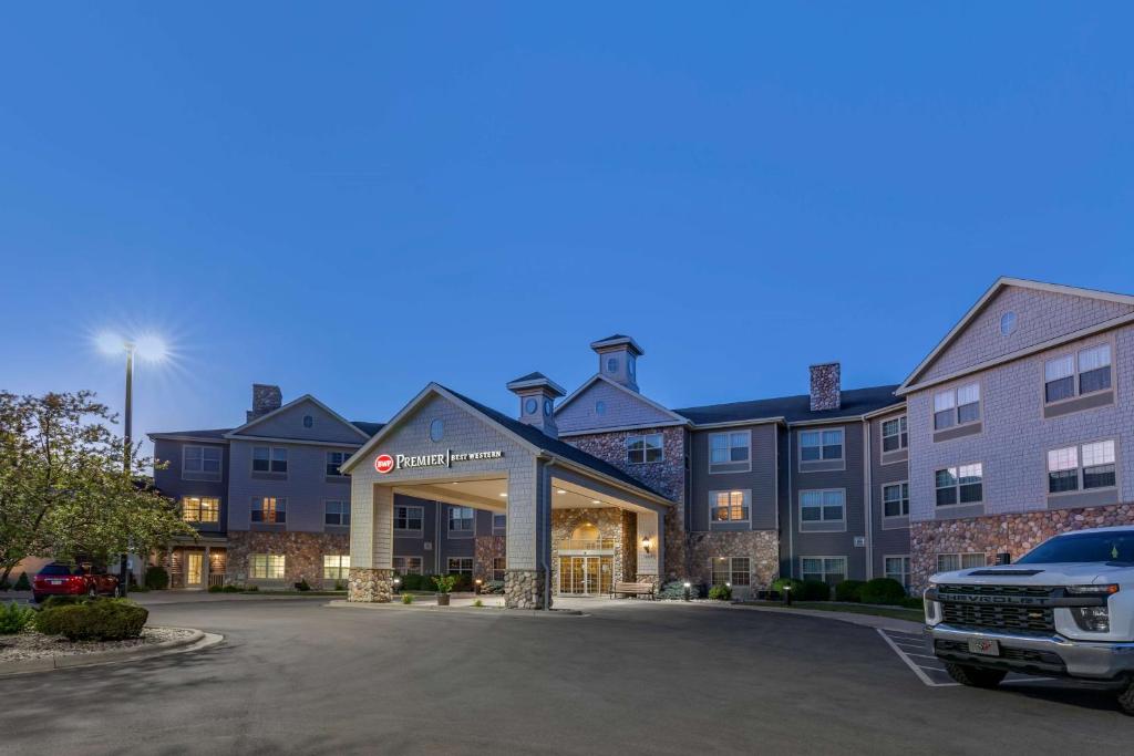 uma vista frontal de um hotel com um camião estacionado num parque de estacionamento em Best Western Premier Bridgewood Hotel Resort em Neenah