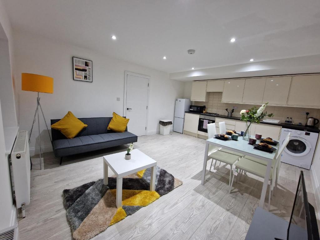 a living room with a couch and a table at Cosy 2 Bedroom Apartment by ReeAni Stays with Wifi, Netflix & Private Parking in Uxbridge