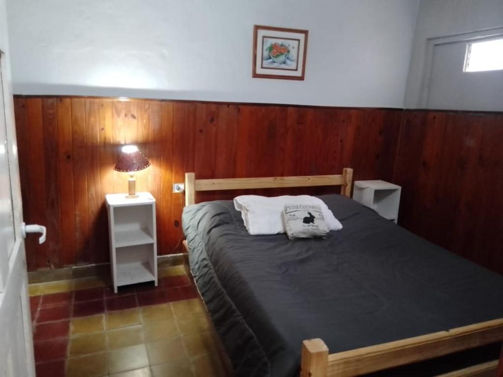 a bedroom with a bed with a wooden wall at La Comodoro in Santiago del Estero