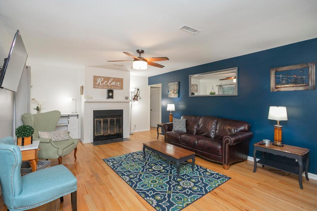 a living room with a leather couch and a fireplace at Fresh in Franklin in Franklin