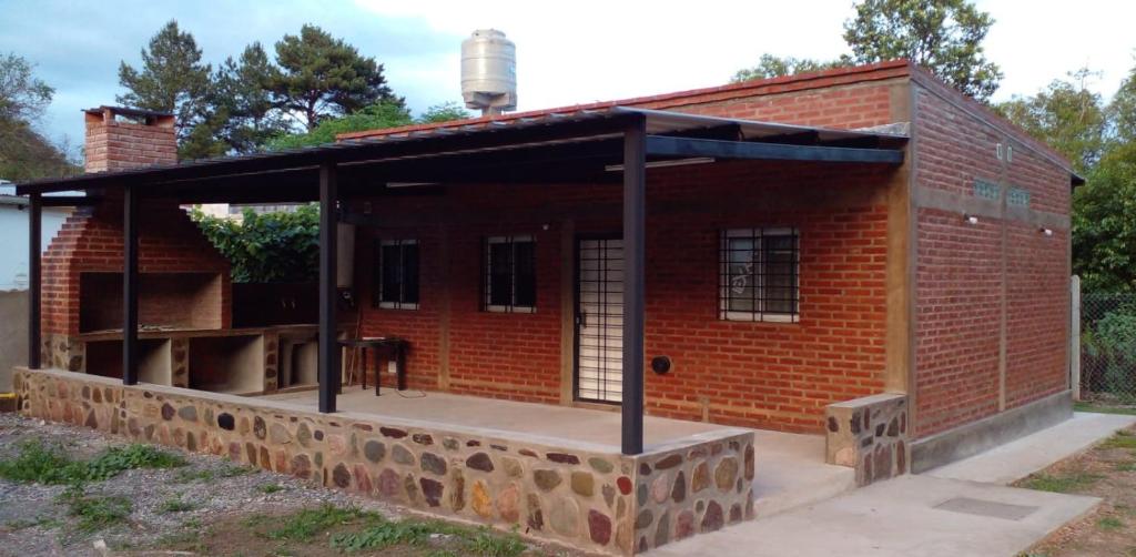 un bâtiment en briques rouges avec un grand toit dans l'établissement Temporario Jujuy Campo, à Lozano