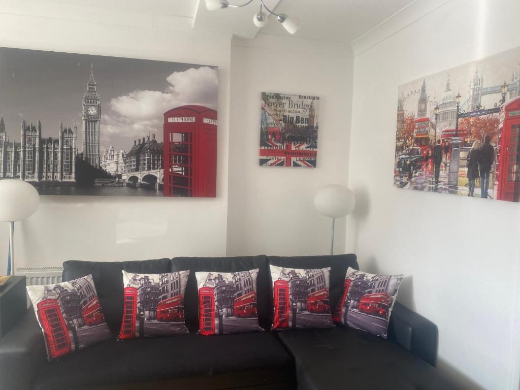 a living room with a couch with pillows and a red phone booth at BRENDA'S APART HOTEL LONDON -Elephant & Castle in London