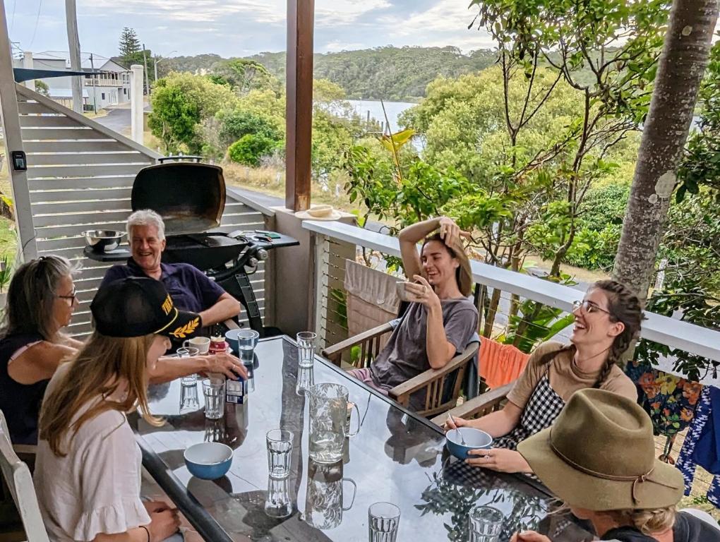 a group of people sitting at a table on a patio at Wooli Holiday Units in Wooli