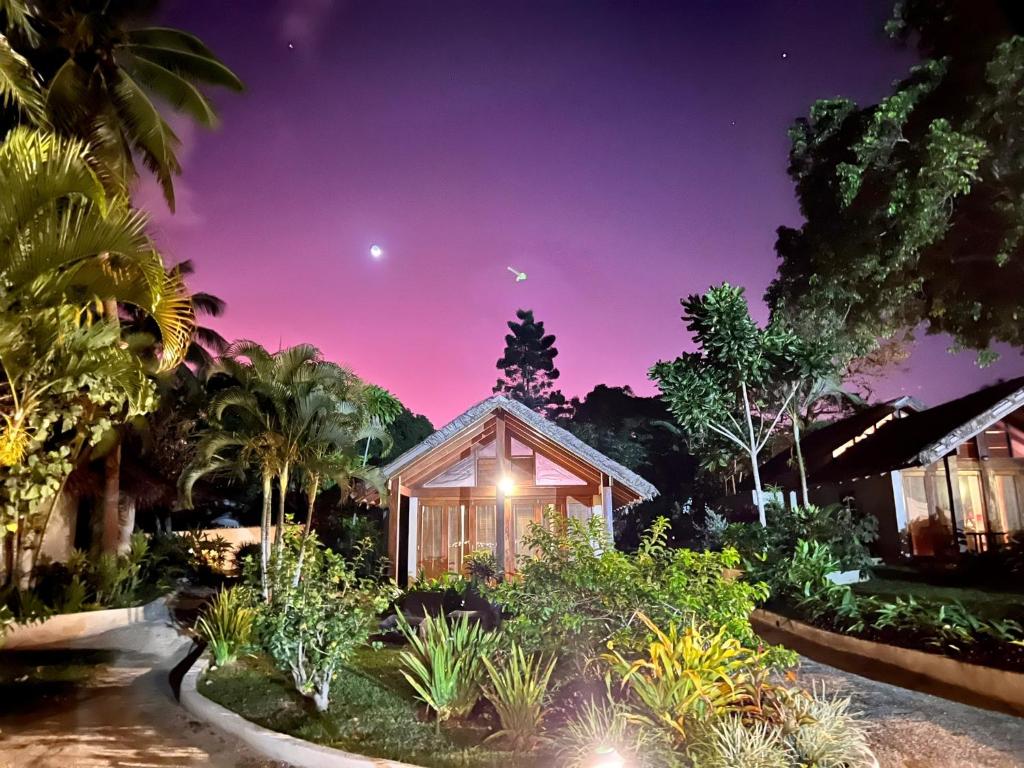 una casa en medio de un jardín por la noche en MG Cocomo Resort Vanuatu, en Port Vila