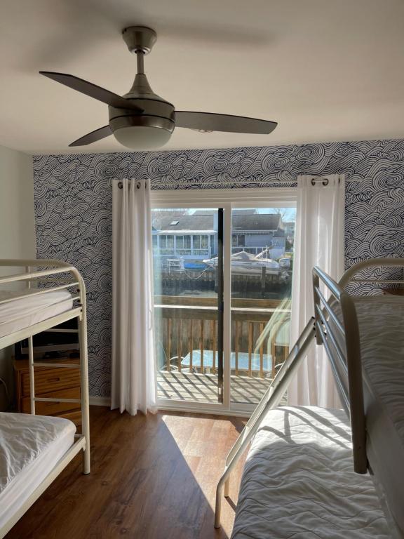 - une chambre avec un ventilateur de plafond et une fenêtre dans l'établissement Ocean City, MD Waterfront Villa, à Ocean City