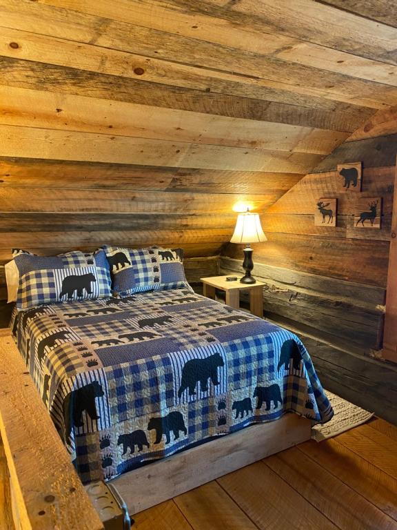 a bedroom with a bed in a wooden ceiling at 1850’s Settlers Cabin at Wethero Ridge & Theater in Hendersonville