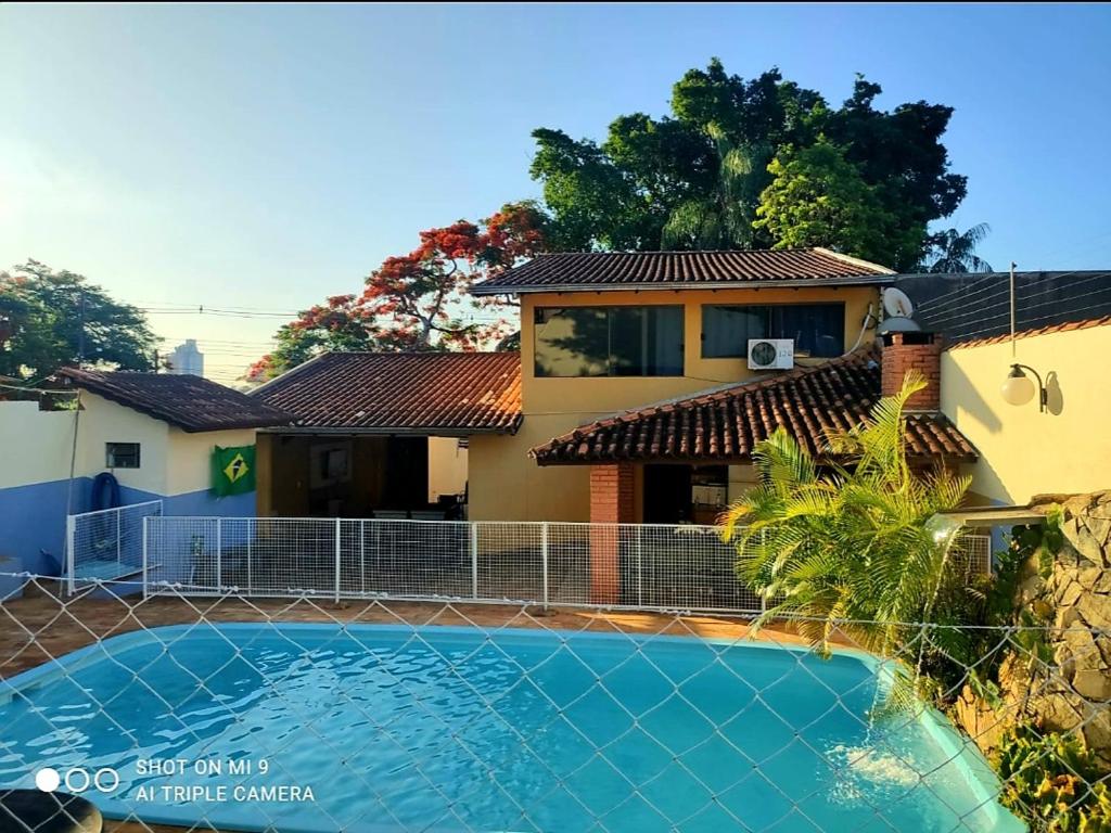 una casa con piscina frente a ella en Hostel Beija flor, en Foz do Iguaçu