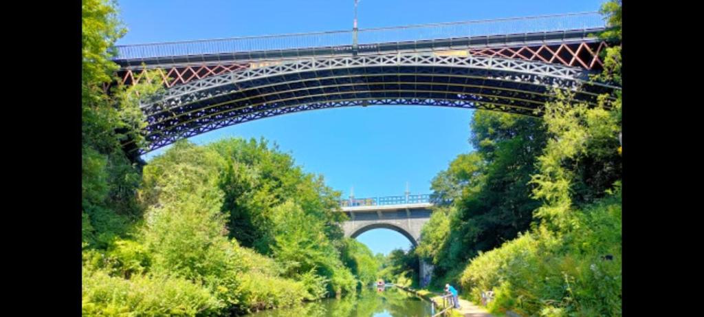 a bridge over a river with a train on it at A home away from home in Birmingham