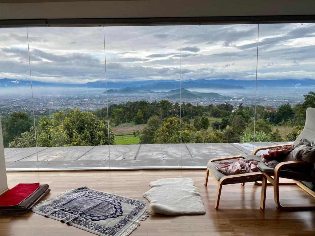 sala de estar con ventana grande con vistas en Villa Adryan Pakuhaji Bandung, en Lembang