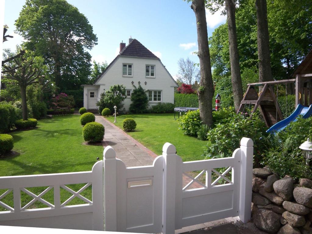 a white fence in front of a white house at Das Lilienhaus in Nieblum
