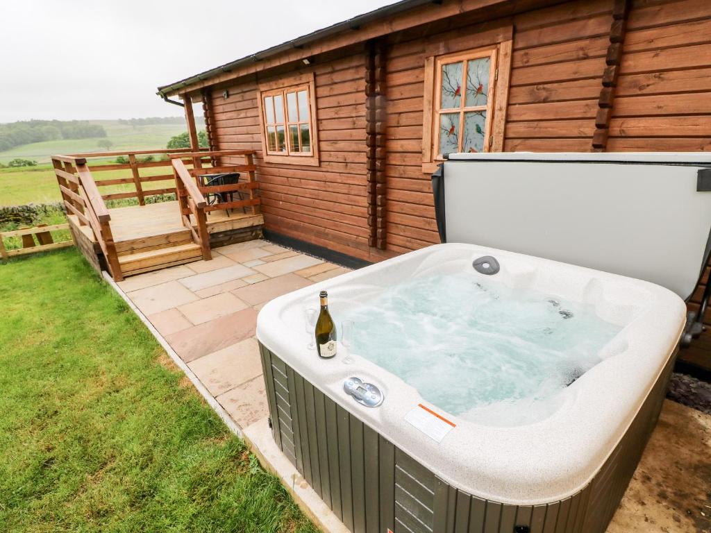 a hot tub in a yard next to a cabin at Curlew in Barnard Castle