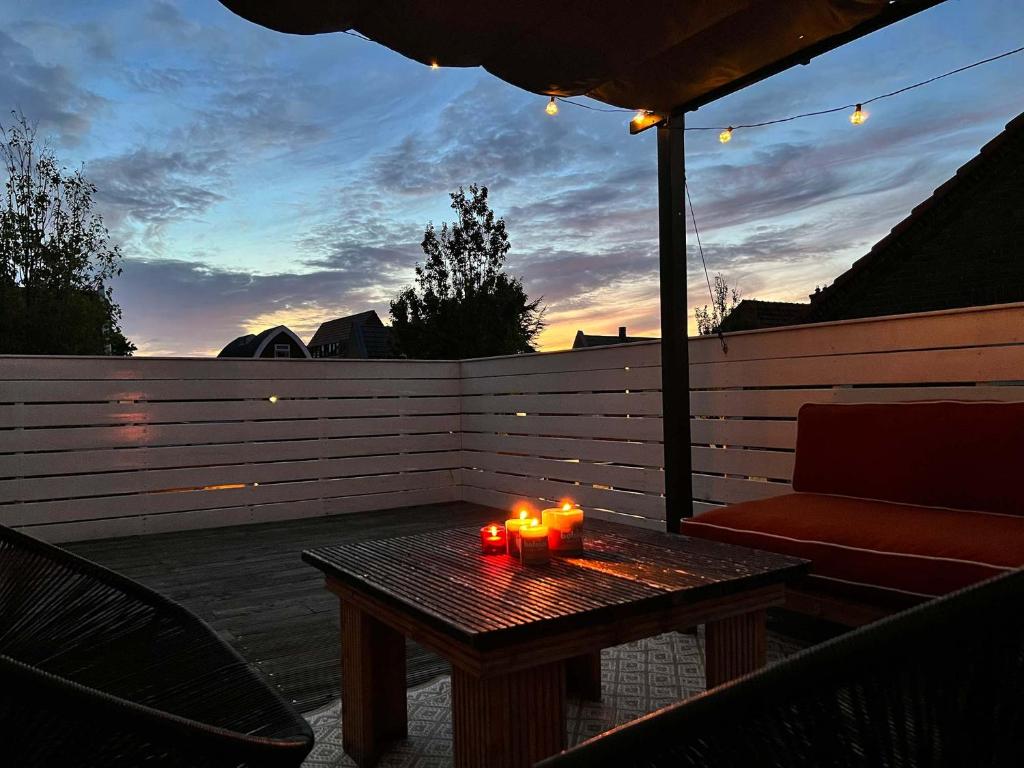 een tafel met kaarsen op een patio met een bank bij Vakantiehuis centrum Schagen nabij zee / strand in Schagen