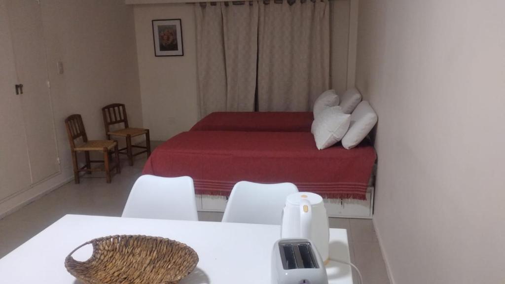 1 dormitorio con 1 cama con manta roja y sillas blancas en Juncal Apartment en Buenos Aires