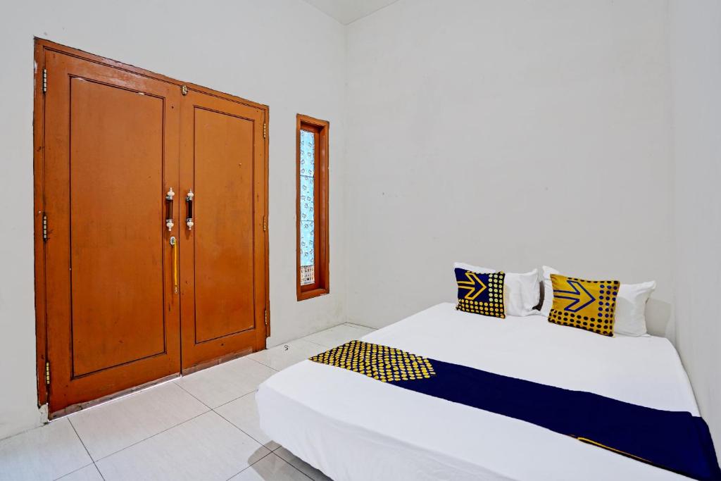 een kamer met twee bedden en een kast erin bij OYO LIFE 92077 Tarlo Guest House 3 in Pradahkalikendal