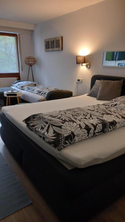 Erholungs- Apartment am Kurpark & Thermen Bad Urach في باد أوراش: غرفة نوم بسريرين في غرفة بها مفرش