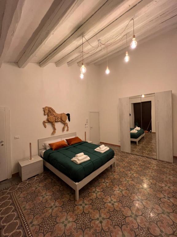 - une chambre dotée d'un lit avec une statue de cheval sur le mur dans l'établissement LB Home, à Termini Imerese