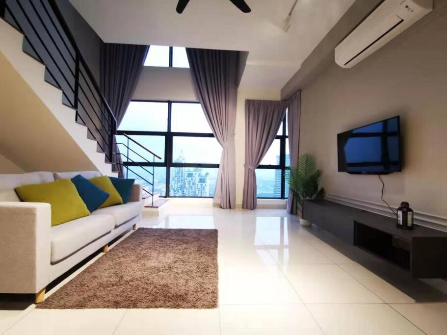 a living room with a couch and a tv at [5-STAR Facilities] ARTE Mont Kiara Luxury Duplex in Kuala Lumpur